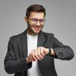 Man,In,Black,Suit,Checks,Smartwatch,With,A,Smile,During